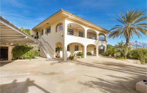 a large white house with a palm tree at 8 Bedroom Awesome Home In Polop in Polop