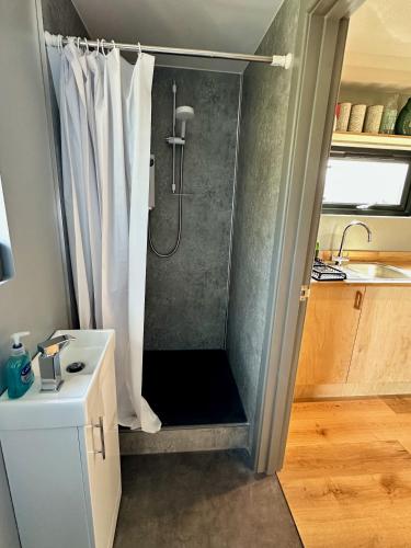 a shower with a shower curtain in a bathroom at Jura - The Black Hut in Isle of Jura