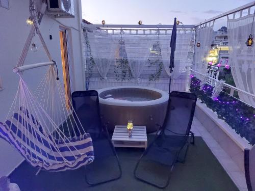 a hammock and two chairs on a balcony with a tub at Delphitea Philoxenia in Itea