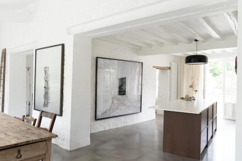 - une cuisine aux murs blancs et une table dans une chambre dans l'établissement Maison dans un village de charme au coeur de la forêt de Fontainebleau, à Recloses