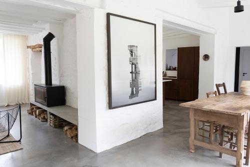 un salon avec une table et une photo sur le mur dans l'établissement Maison dans un village de charme au coeur de la forêt de Fontainebleau, à Recloses