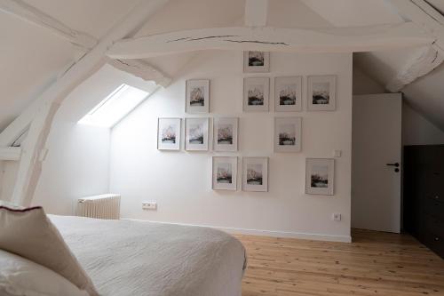 - une chambre blanche avec des photos sur le mur dans l'établissement Maison dans un village de charme au coeur de la forêt de Fontainebleau, à Recloses