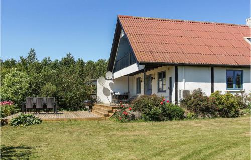 a house with a red roof and a wooden deck at Amazing Home In Klemensker With Wifi in Klemensker
