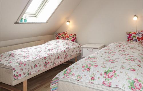 two beds in a small room with a window at Amazing Home In Klemensker With Wifi in Klemensker