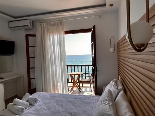 a bedroom with a bed and a view of the ocean at Akrogiali in Agios Ioannis Pelio