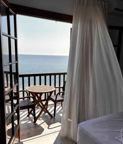 a bedroom with a bed and a view of the ocean at Akrogiali in Agios Ioannis Pelio