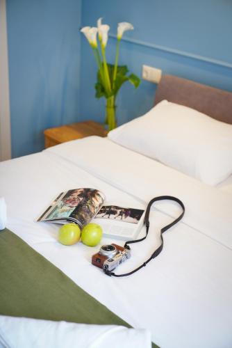 a photo of a camera and a magazine on a bed at Station 22 Hotel in Batumi