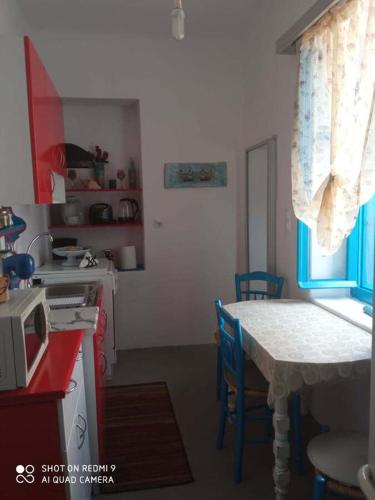 a kitchen with a table and a table and a microwave at Welcome to Giouli's home ! in Elafonisos