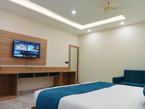 a bedroom with a bed and a tv on the wall at Hotel W Grand - A Boutique Hotel in Haridwār