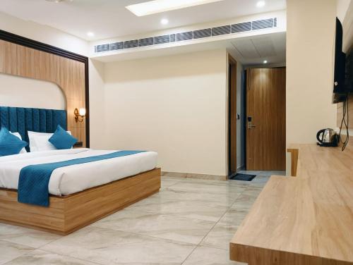 a bedroom with a large bed with blue pillows at Hotel W Grand - A Boutique Hotel in Haridwār