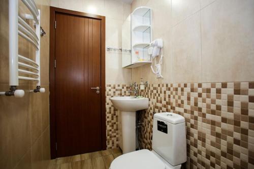 un baño con inodoro y lavabo en Tbilisi center, Nino's Art Apartment, en Tiflis