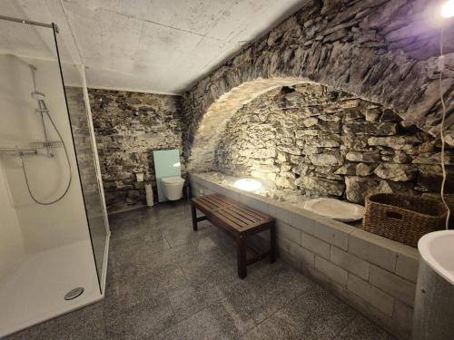 a stone bathroom with a sink and a toilet at Casa Grillino in Locarno