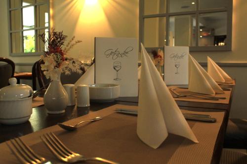 a table with white napkins and utensils on it at Hotel Reke in Plau am See