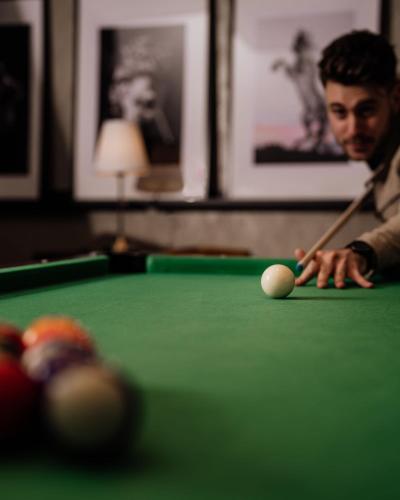 a man playing billiard with a cue on a pool table at Bohusgården Hotell & Konferens in Uddevalla
