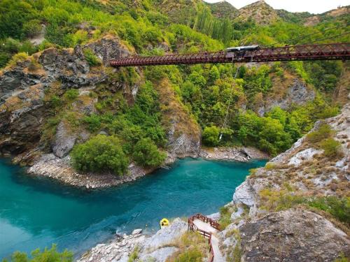 a train crossing a bridge over a river at Oaks Queenstown Club Suites in Queenstown
