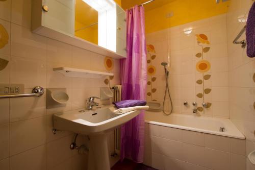 uma casa de banho com um lavatório, um chuveiro e uma banheira em Ariete Apartments em Livigno