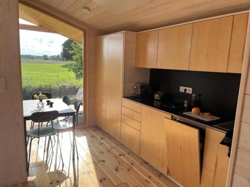 a kitchen with a table and a view of a field at 104 Tinyhouse mit Wiesenblick in Bleckede