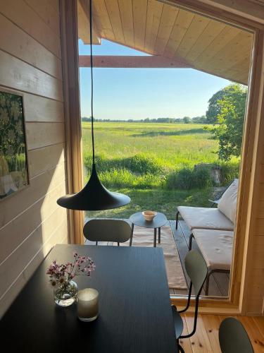a room with a table and a view of a field at 104 Tinyhouse mit Wiesenblick in Bleckede