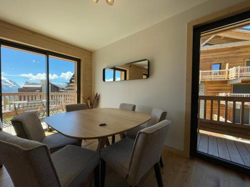 une salle à manger avec une table et des chaises et une fenêtre dans l'établissement Homency - Résidence Chalets du Golf - Birdy B202, à L'Alpe-d'Huez