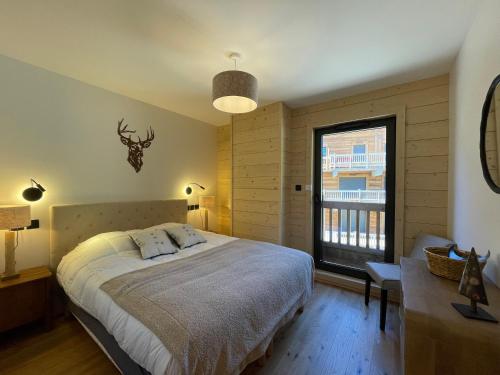 une chambre avec un grand lit et une fenêtre dans l'établissement Homency - Résidence Chalets du Golf - Birdy B202, à L'Alpe-d'Huez