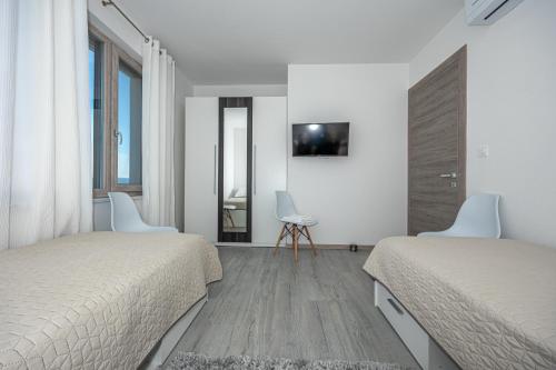 a white bedroom with two beds and a table and chairs at Luxury White Sails Villas with a Multi Sport Court #2026# and Sea View in Pinezici