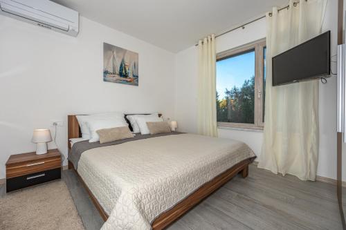 a bedroom with a bed and a flat screen tv at Luxury White Sails Villas with a Multi Sport Court #2026# and Sea View in Pinezici