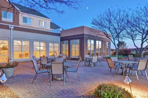 a patio with tables and chairs in front of a building at Hilton Garden Inn Oshkosh in Oshkosh