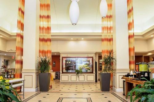 a lobby of a hotel with potted plants at Hilton Garden Inn Oshkosh in Oshkosh