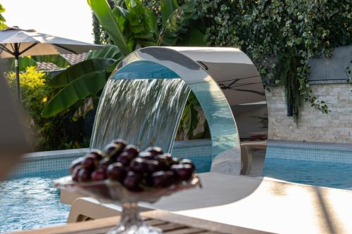 a water fountain with a bunch of fruit on a table at Luxury White Sails Villas with a Multi Sport Court #2026# and Sea View in Pinezici