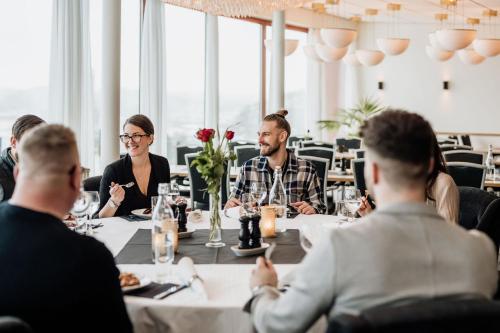 a group of people sitting around a table in a restaurant at Bohusgården Hotell & Konferens in Uddevalla
