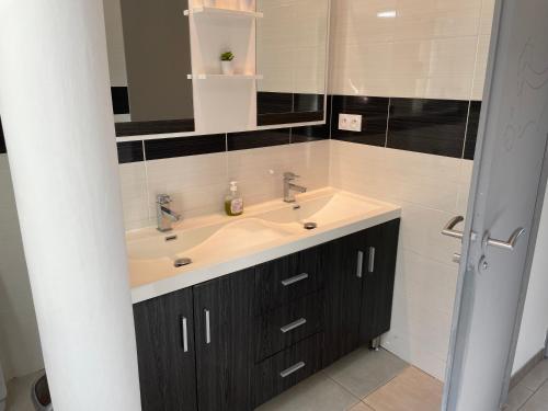 Un baño con lavabo y un espejo grande. en Villa Perle du Rouergue, en Villefranche-de-Rouergue