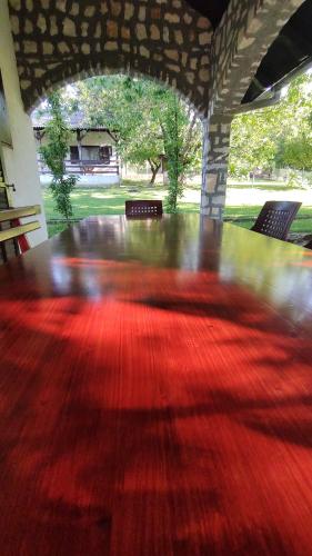 a large wooden table in a pavilion with a red floor at Gorska Vila Sisevac in Sisevac