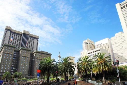 a city with palm trees in front of tall buildings at Post Hotel in San Francisco