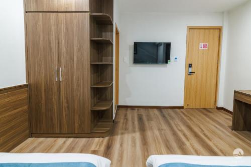 a room with a closet and a tv in it at Aquatic Hotel Cat Ba in Cat Ba