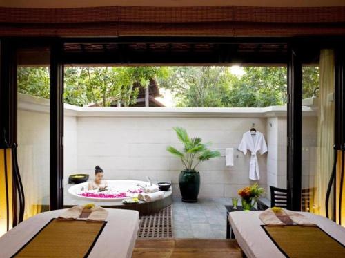 a bathroom with a bath tub and a man in a bath tub at Angkor Village Resort & Spa in Siem Reap
