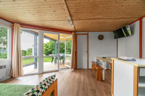 a kitchen and dining room with sliding glass doors at Camping Le Mont Libre - Cottage & espace nature - Gannat in Gannat