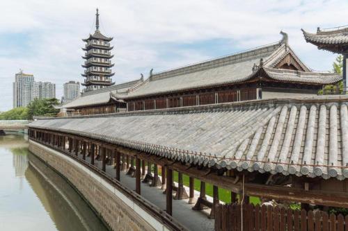 a building with a roof next to a river at Kingtown Hotel Hongqiao Shanghai in Shanghai