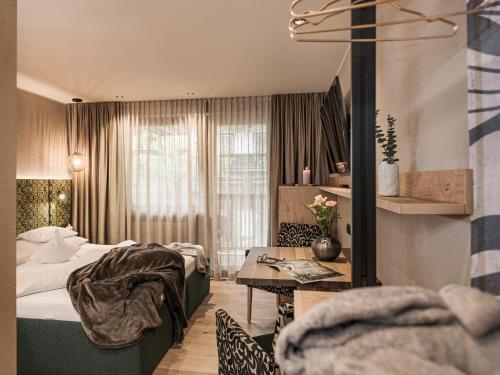 pokój hotelowy z łóżkiem i stołem w obiekcie Hotel Sieghard Zillertal w Mayrhofen