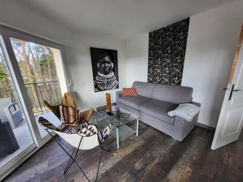 a living room with a couch and a chair at Aparthotel Des 2 Caps in Ambleteuse