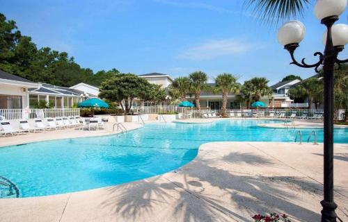 a large swimming pool with chairs and umbrellas at Sea Trail Golf Resort & Convention Center in Sunset Beach