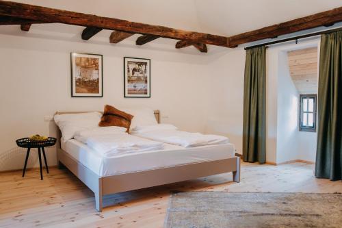 a bedroom with a white bed in a room at Ugron Castle Fiatfalva in Cristuru Secuiesc