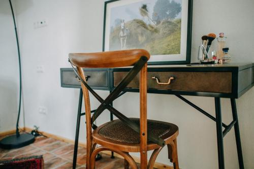 a wooden chair sitting in front of a desk at Ugron Castle Fiatfalva in Cristuru Secuiesc