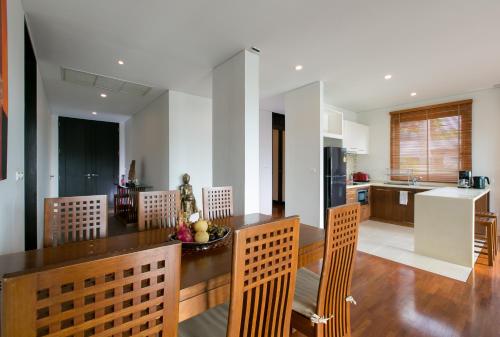 a kitchen with a table and chairs in a kitchen at Kata Gardens Penthouse sea view 4C near Kata Noi Beach in Kata Beach