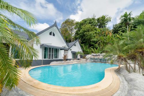 a swimming pool in front of a house at Villa Olympus Ocean Vista Kata Beach in Kata Beach