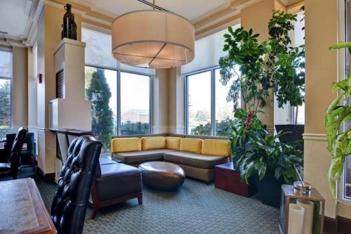 a living room with a couch and some plants at Hilton Garden Inn Green Bay in Green Bay
