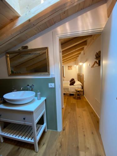 a bathroom with a sink and a room with a bed at Pedegagia in Vezzano