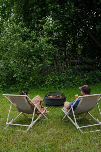 two people sitting in lawn chairs next to a fire at Zen Sasino in Sasino