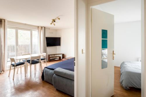 une chambre avec un lit, un bureau et une table dans l'établissement OASIS de tranquillité avec Terrasse à 15 min PARIS, à Choisy-le-Roi