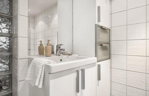 a white bathroom with a sink and a mirror at Cozy nest- walking distance to city center in Bergen