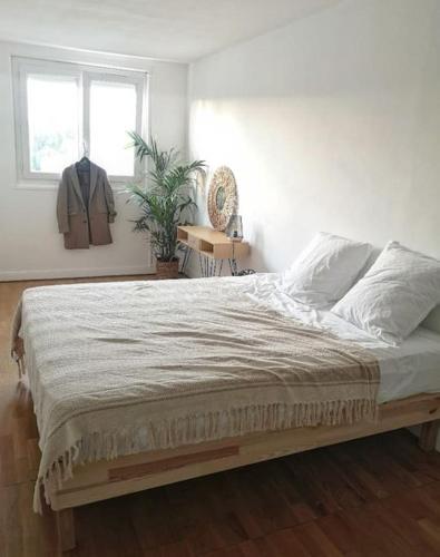 ein Schlafzimmer mit einem großen Bett mit Fenster in der Unterkunft Appartement proche centre avec parking gratuit in Sèvres